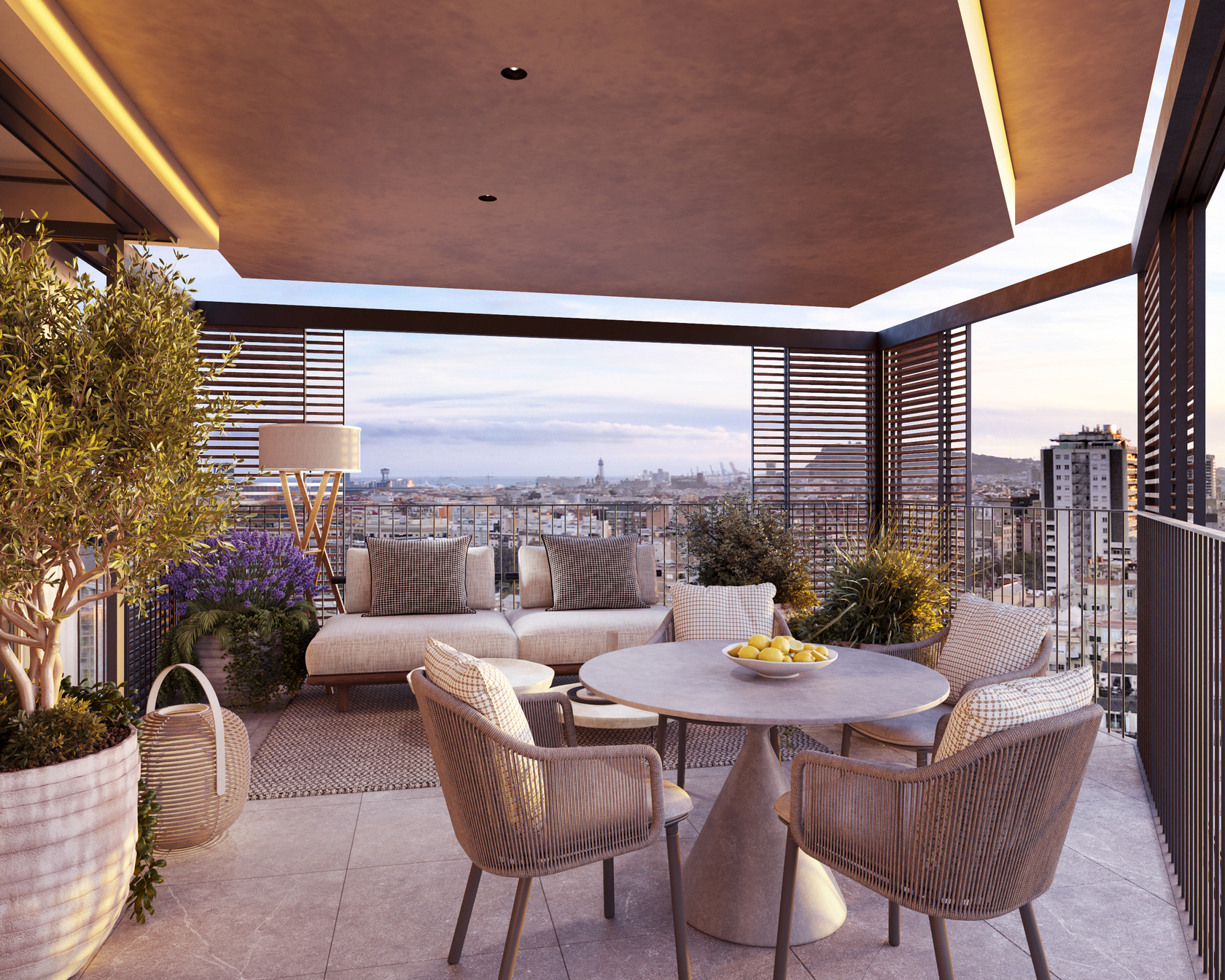 Private terrace with a round dining table, a lounge sofa, olive trees and wooden slat screens, framing the Torre Glòries and the city skyline.